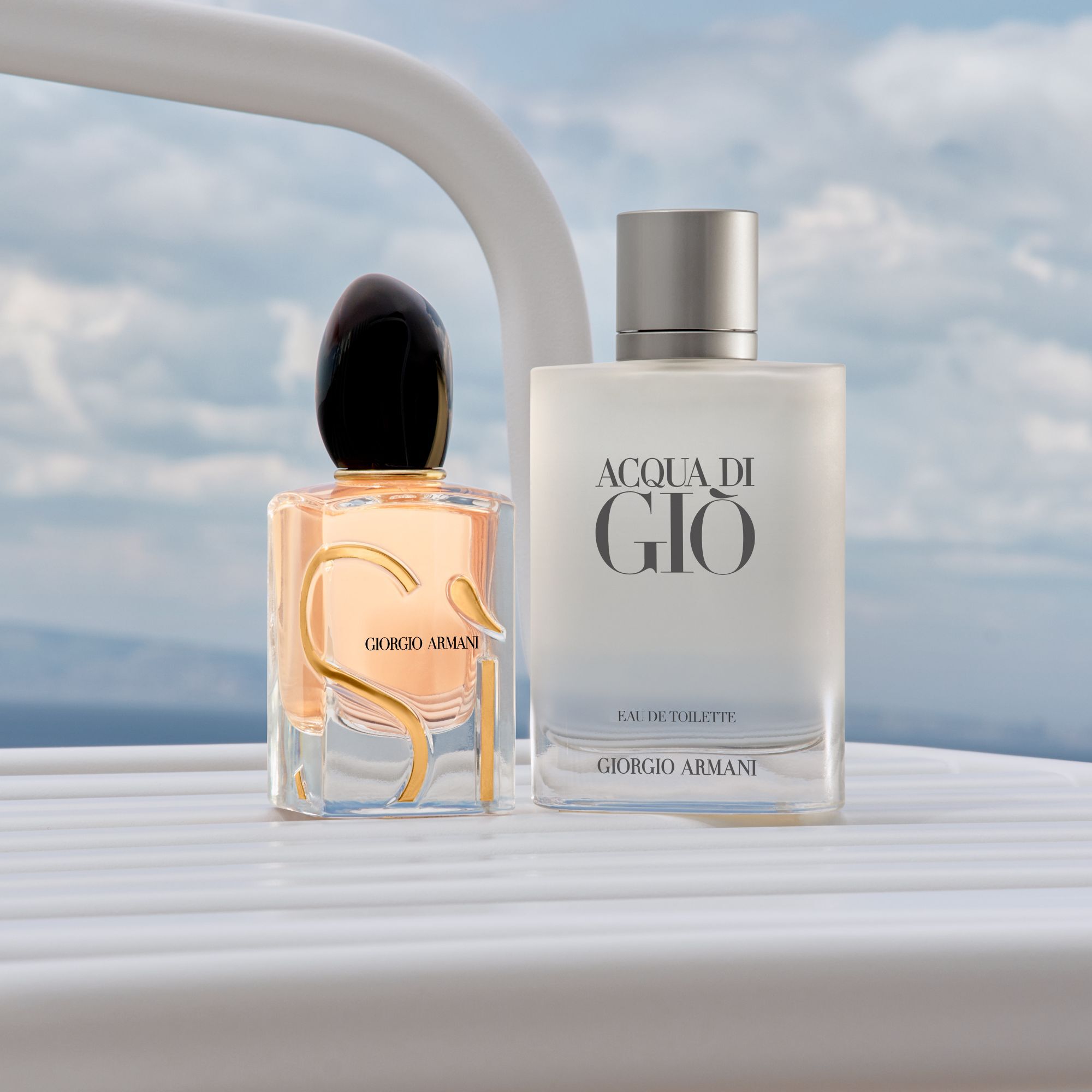 Un duo raffinato di icone Armani: il radioso Si e il fresco Acqua di Gio. Adagiati sul parapetto di uno yacht bianco davanti a un mare sereno, incarnano un'eleganza senza tempo e lo spirito di una lussuosa fuga sulla costa.