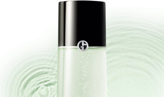 Flacone di prodotto di bellezza con etichetta elegante su sfondo verde chiaro e onde d'acqua.