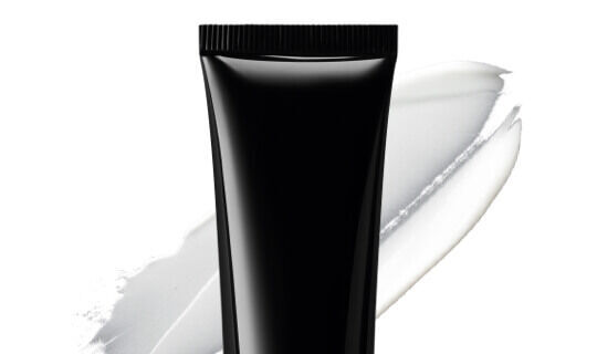 Un tubo di crema nera con una striscia di crema bianca sullo sfondo.
