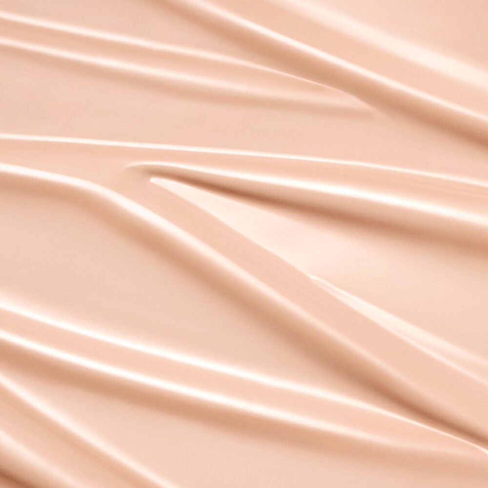 Close-up of smooth, glossy fabric with soft folds and a warm beige tone.