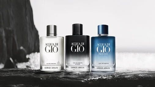 Three Armani fragrance bottles on a wet surface, emphasizing the brand’s elegant and aquatic identity.