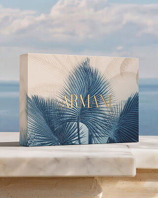 Un raffinato set regalo Armani con motivo botanico blu, su una base di marmo davanti al mare. Un omaggio alla collezione "Armani Mare", che unisce artigianalita couture ed eleganza solare per un rito di bellezza unico.
