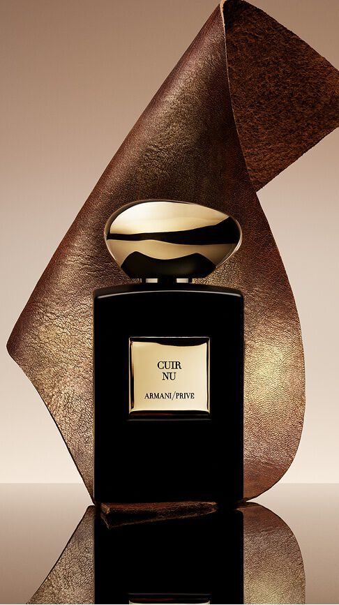 Armani/Prive Cuir Nu: un elegante flacone nero con tappo dorato, avvolto in un nastro di pelle testurizzata, che incarna la sensualita della pelle nuda e la raffinata scia legnosa e cuoiata.