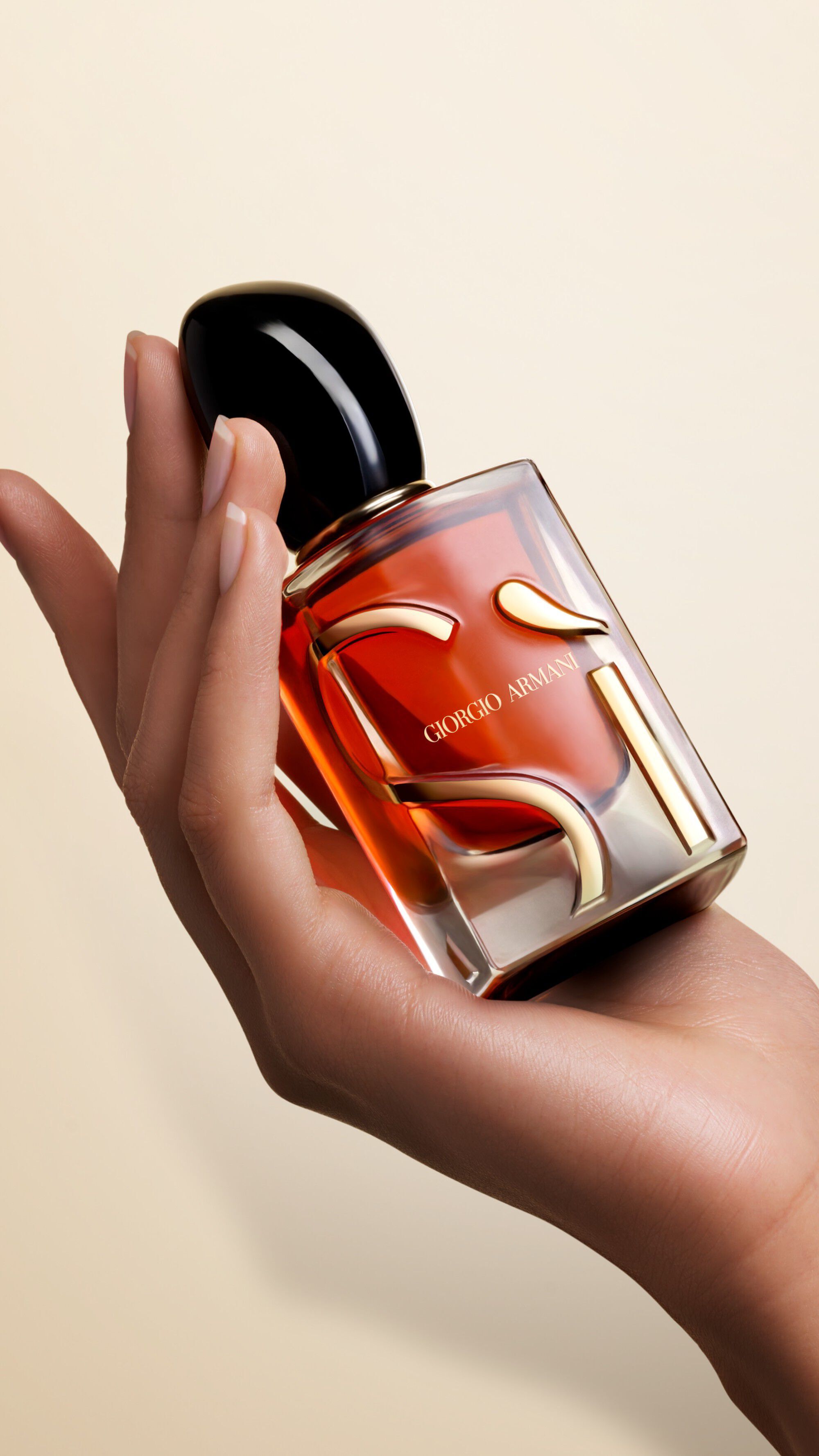 Una mano che tiene una bottiglia di SI PARFUM