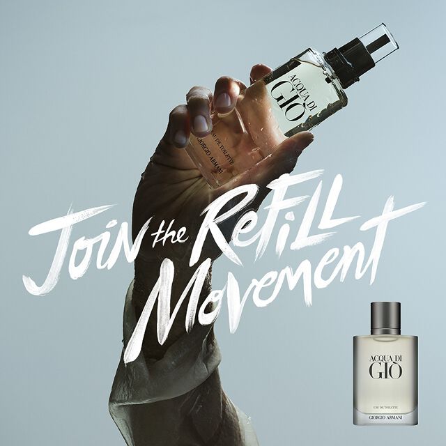 Un visual potente: una mano sorregge la ricarica Acqua di Gio davanti al cielo, con la scritta "Join the Refill Movement". Simbolo del lusso sostenibile e dell'intramontabile freschezza marina firmata Armani Beauty.