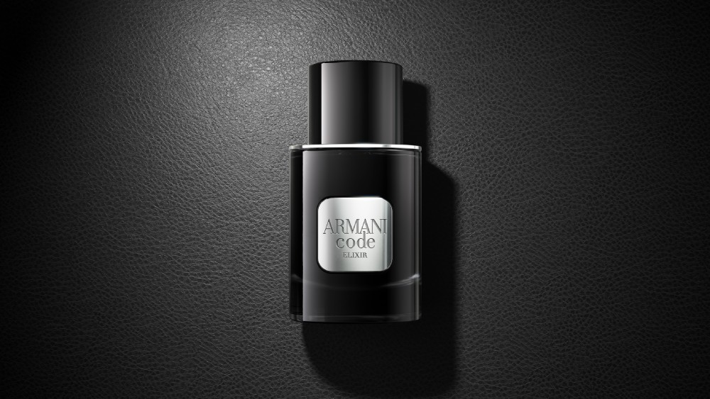 Un flacone nero del profumo Armani Code Elixir poggia elegantemente su una superficie nera coordinata, creando un sofisticato look monocromatico.